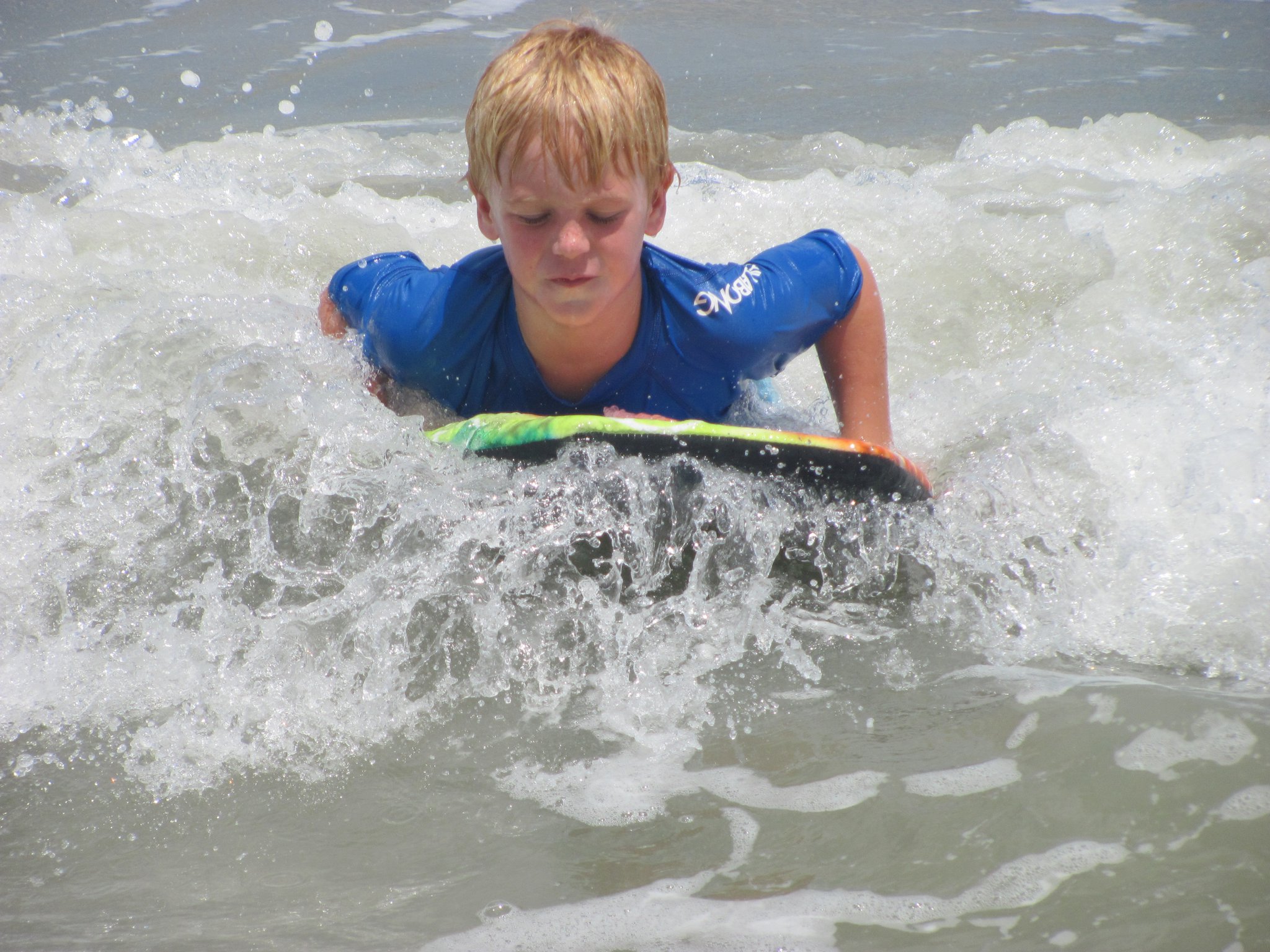 boy paddling out on surfboard
